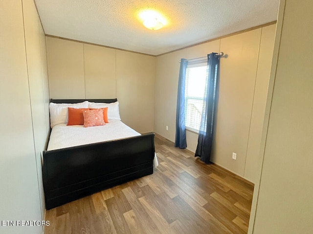 unfurnished bedroom with light hardwood / wood-style floors and a textured ceiling