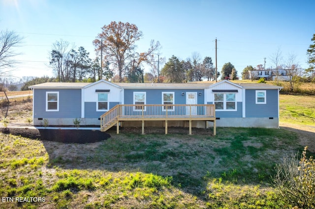 rear view of property with a deck, a yard, and crawl space