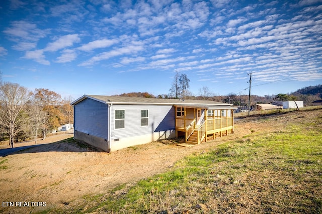 rear view of house featuring crawl space and dirt driveway