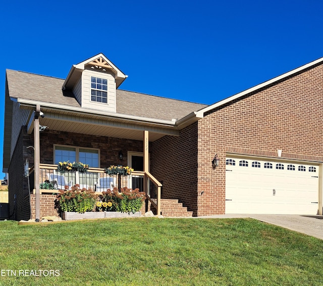 view of front of house with a garage, a front lawn, and a porch