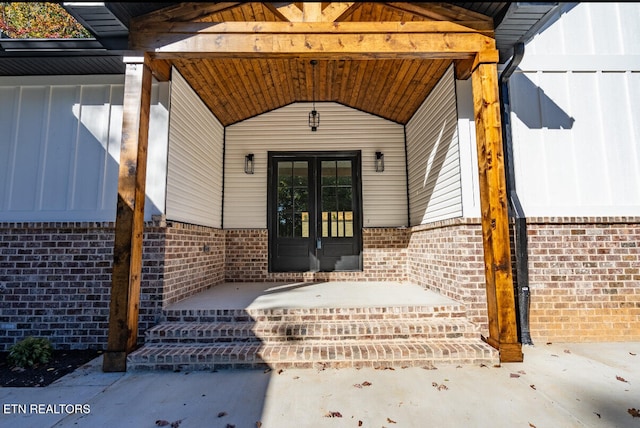 doorway to property featuring french doors and brick siding