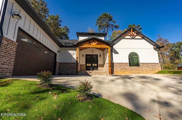 modern farmhouse with a garage and a front lawn