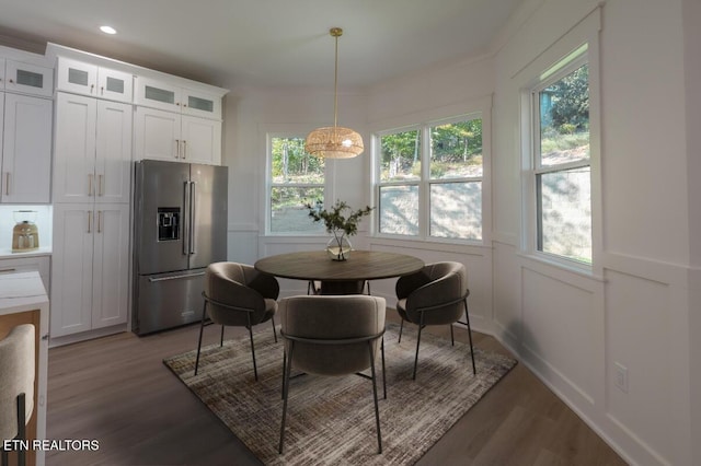 dining area featuring a decorative wall, recessed lighting, wood finished floors, and a wainscoted wall