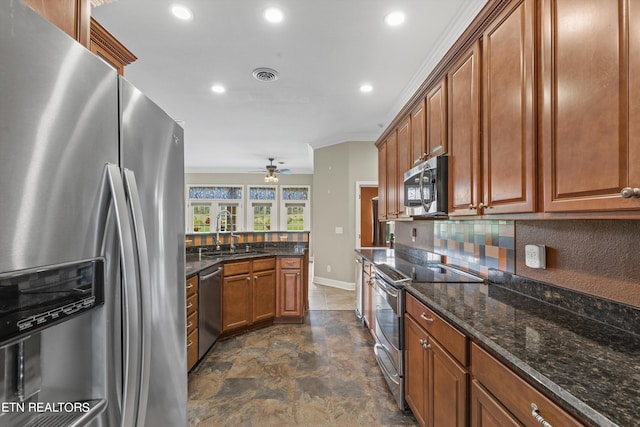 kitchen with appliances with stainless steel finishes, dark stone countertops, tasteful backsplash, crown molding, and sink