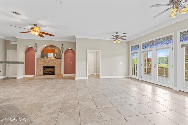 unfurnished living room with a fireplace, light tile patterned floors, ceiling fan, french doors, and ornamental molding