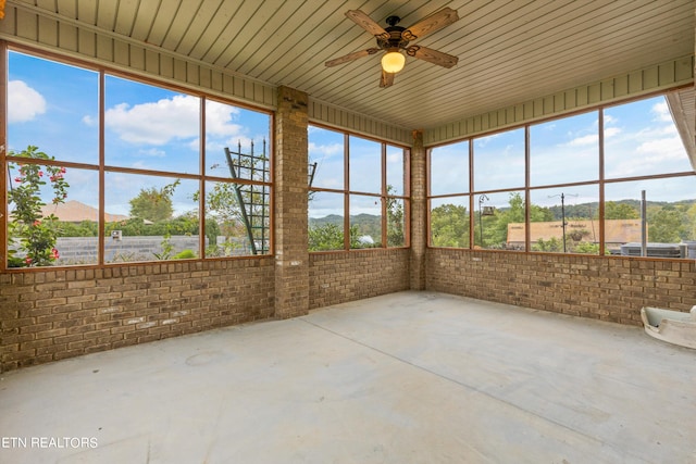 unfurnished sunroom with ceiling fan