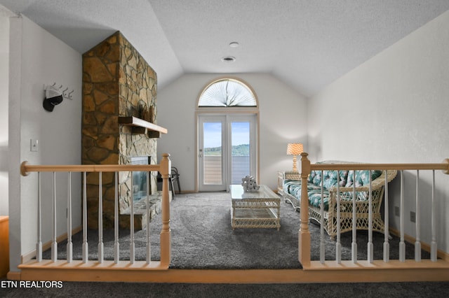 unfurnished living room featuring carpet floors, a textured ceiling, a fireplace, and vaulted ceiling