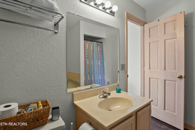 bathroom with wood-type flooring, vanity, and toilet