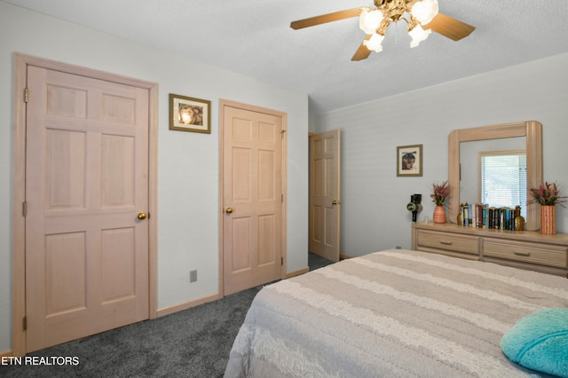 carpeted bedroom featuring ceiling fan and a textured ceiling