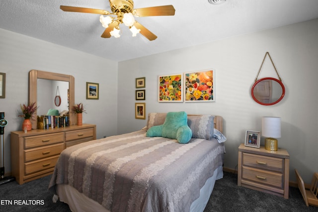 carpeted bedroom with ceiling fan and a textured ceiling