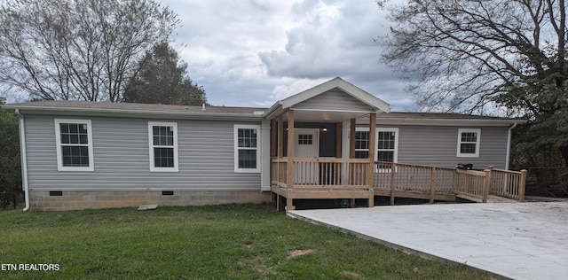 rear view of property with a lawn and a wooden deck