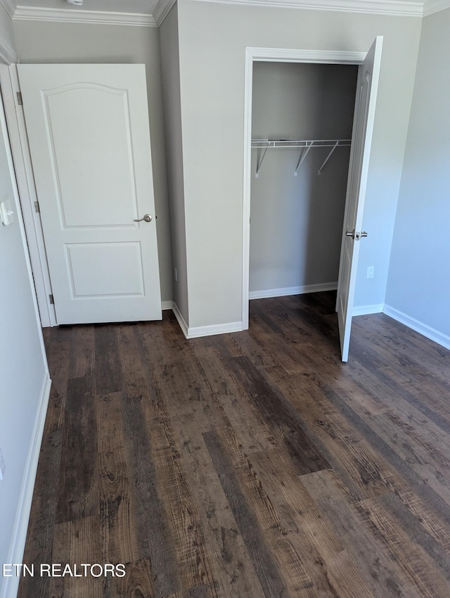 unfurnished bedroom featuring a closet, crown molding, and dark hardwood / wood-style flooring