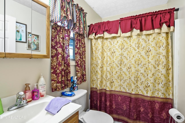 bathroom featuring vanity, toilet, a textured ceiling, and walk in shower