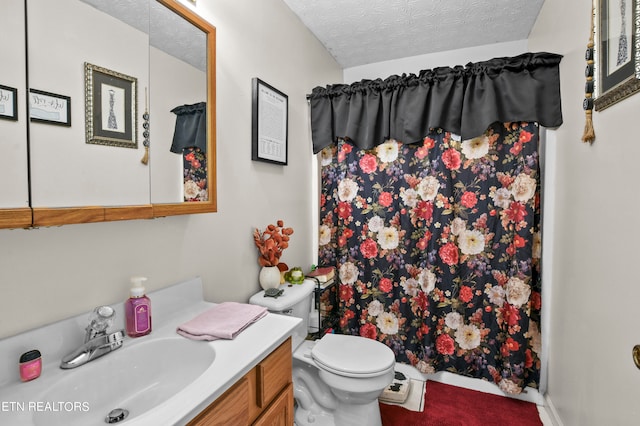 bathroom with vanity, toilet, and a textured ceiling