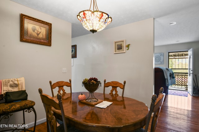 dining room featuring a notable chandelier and dark wood-type flooring