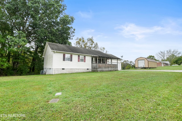 view of front of property with a front yard, a garage, cooling unit, and an outdoor structure