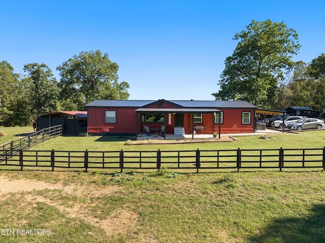 ranch-style home featuring a rural view, a front yard, and covered porch