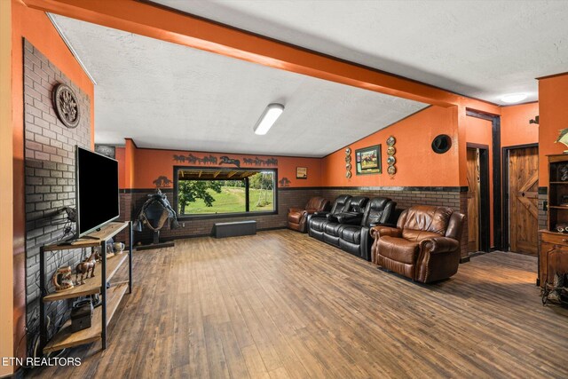 living room with hardwood / wood-style floors, lofted ceiling with beams, and a textured ceiling