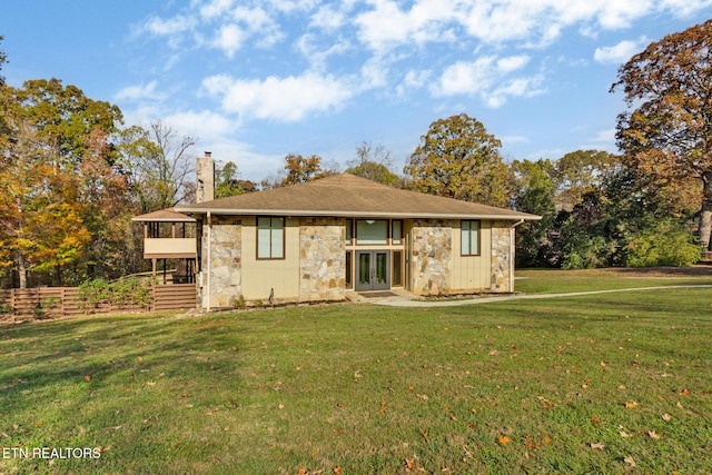 back of house featuring a yard, french doors, and a balcony