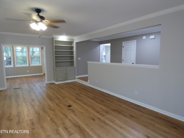 unfurnished living room featuring ceiling fan, hardwood / wood-style flooring, crown molding, and built in features