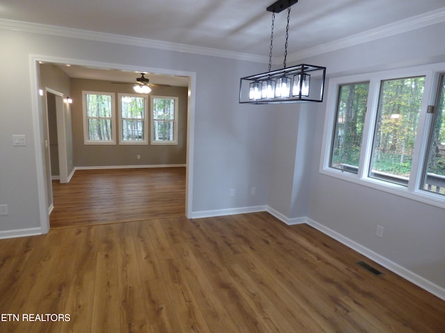 unfurnished dining area featuring wood-type flooring, crown molding, and ceiling fan