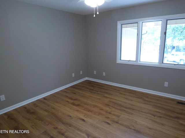 spare room featuring dark hardwood / wood-style flooring and ceiling fan