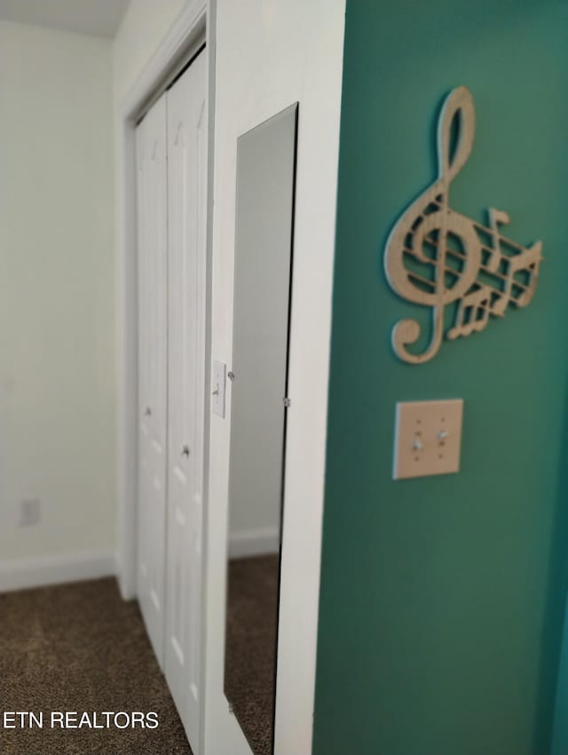 hallway featuring dark carpet