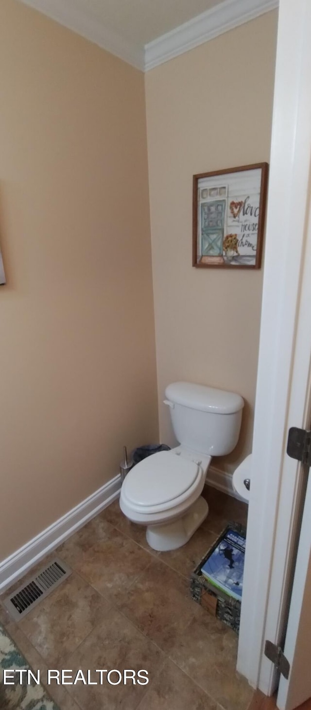 bathroom with ornamental molding and toilet