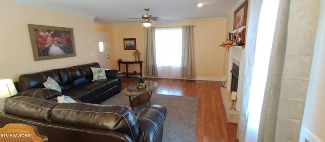 living room with light hardwood / wood-style floors, ornamental molding, and ceiling fan