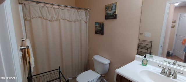 bathroom with curtained shower, vanity, and toilet