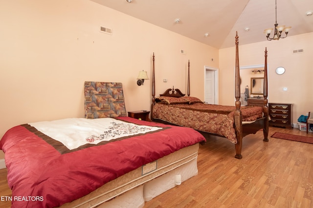 bedroom featuring a chandelier, light hardwood / wood-style floors, and high vaulted ceiling