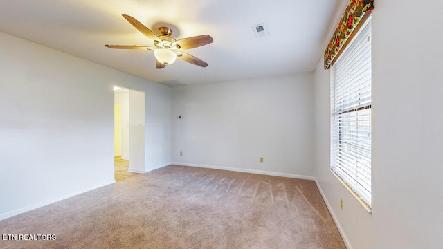 carpeted spare room featuring ceiling fan