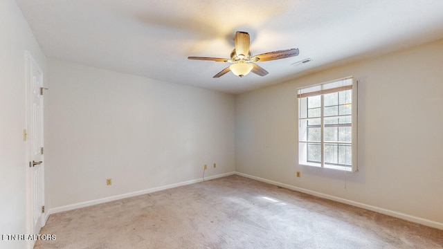 carpeted spare room with ceiling fan