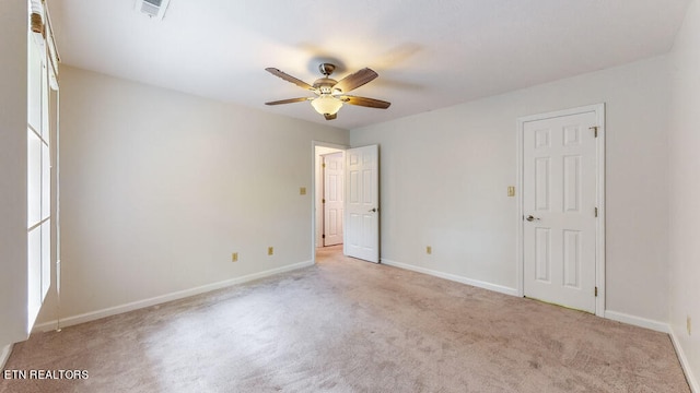 carpeted spare room with ceiling fan