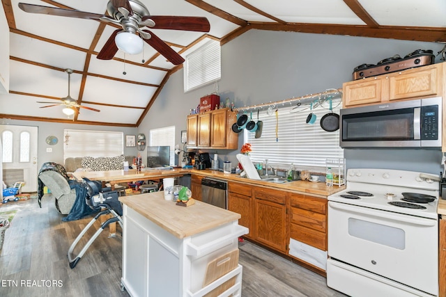 kitchen featuring stainless steel appliances, vaulted ceiling with beams, light hardwood / wood-style floors, and butcher block countertops