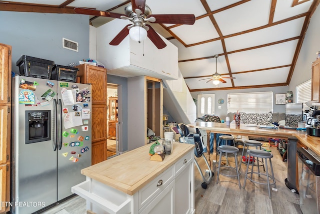 kitchen with white cabinets, lofted ceiling, stainless steel appliances, light wood-type flooring, and butcher block counters