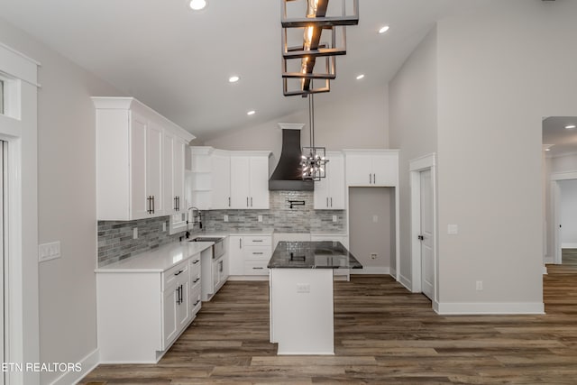 kitchen with sink, a kitchen island, dark hardwood / wood-style floors, white cabinets, and custom exhaust hood