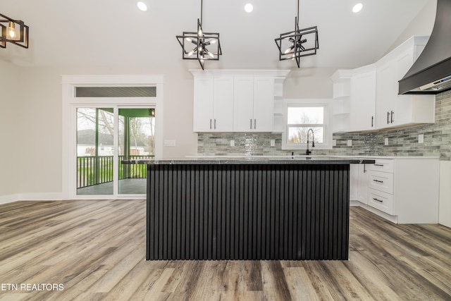 kitchen featuring white cabinetry, plenty of natural light, a center island, and custom range hood