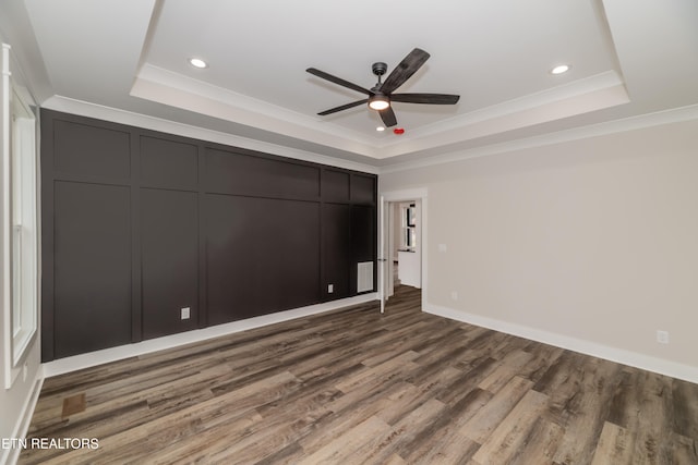 unfurnished bedroom with a raised ceiling, ceiling fan, crown molding, and hardwood / wood-style flooring