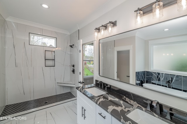 bathroom with tiled shower, a wealth of natural light, and ornamental molding