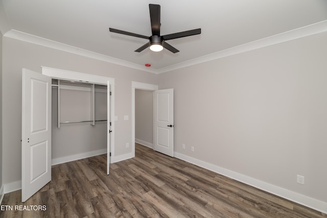 unfurnished bedroom with dark hardwood / wood-style flooring, a closet, ceiling fan, and ornamental molding