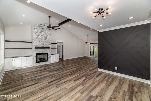 unfurnished living room featuring a fireplace, wood-type flooring, lofted ceiling with beams, and ceiling fan with notable chandelier