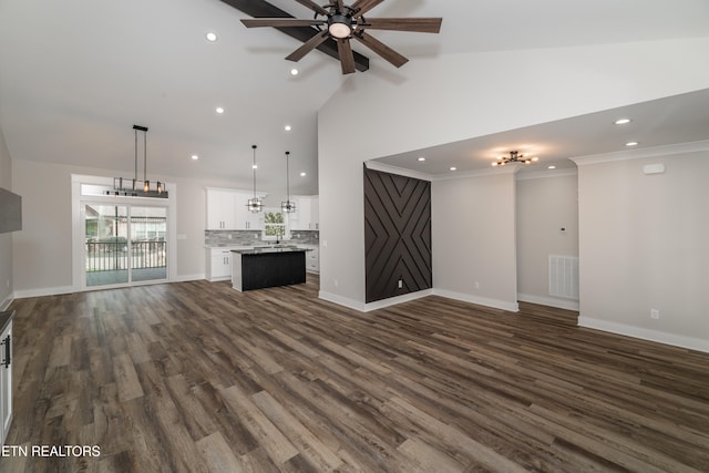 unfurnished living room featuring ceiling fan, crown molding, dark wood-type flooring, and high vaulted ceiling