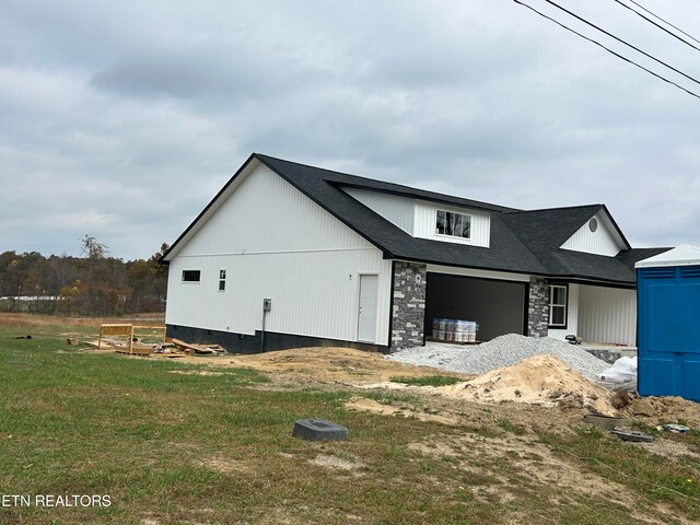 view of property exterior with a garage and a lawn