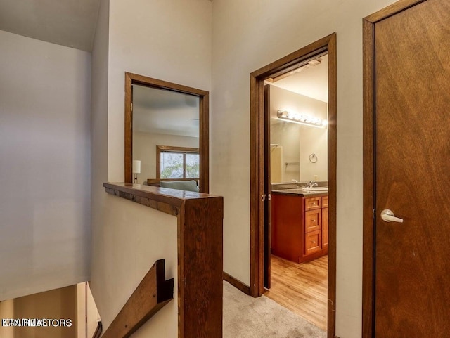 hall with light hardwood / wood-style floors and sink