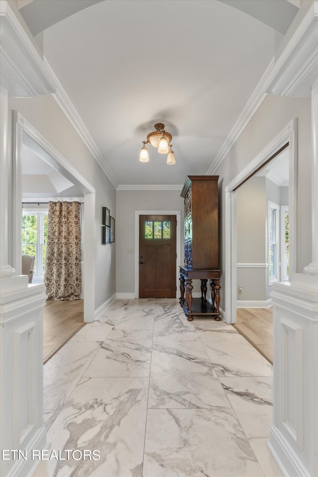 entrance foyer with ornamental molding and ornate columns