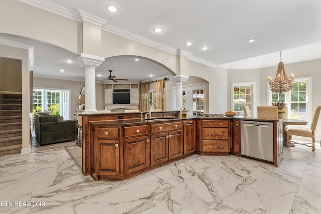 kitchen with pendant lighting, ornamental molding, sink, stainless steel dishwasher, and ceiling fan with notable chandelier