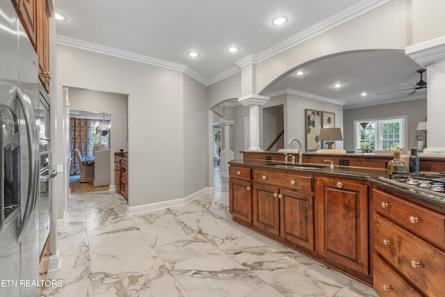 kitchen featuring sink, appliances with stainless steel finishes, ornamental molding, ceiling fan, and ornate columns