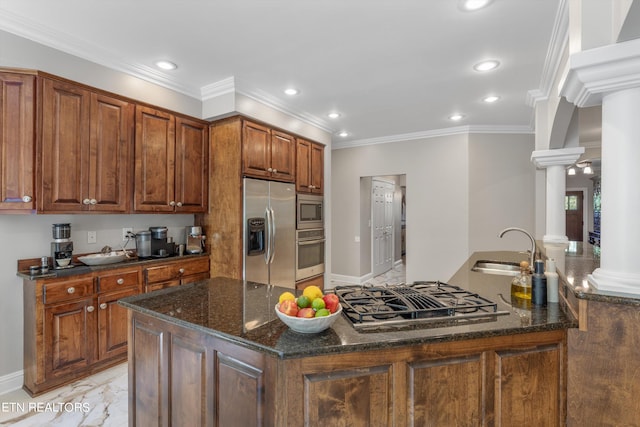 kitchen featuring dark stone countertops, appliances with stainless steel finishes, crown molding, and ornate columns