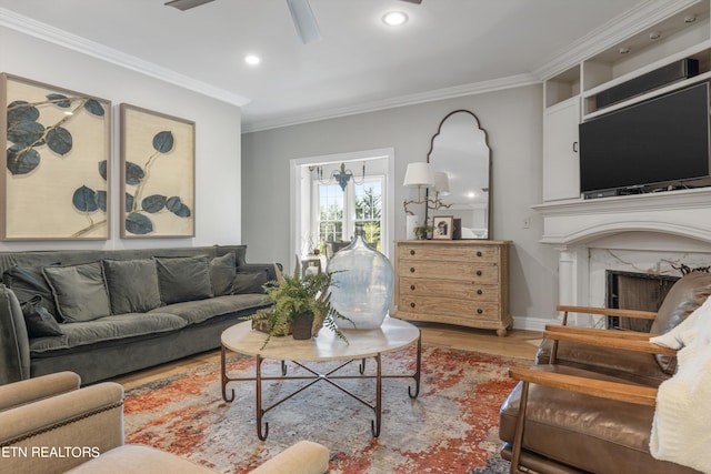 living room with ornamental molding, ceiling fan, hardwood / wood-style flooring, and a fireplace